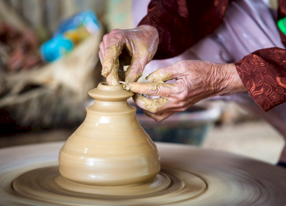 Strolling through the narrow alleys of Thanh Ha Pottery Village, visitors often encounter artisans passionately working at the wheel 